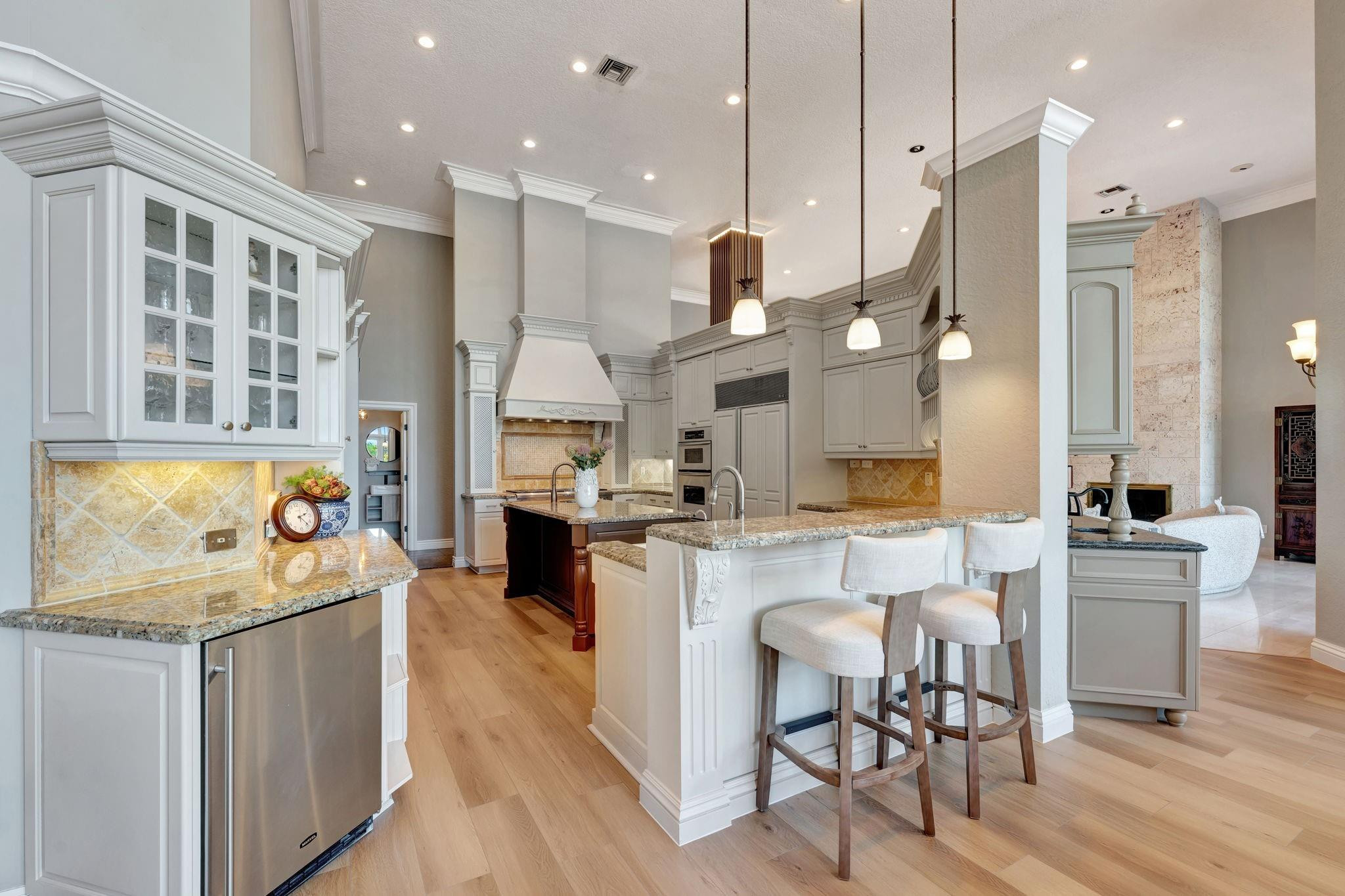 3460 Windmill Ranch Road Weston, FL 33331 - Photo 24 of 75 a kitchen with stainless steel appliances kitchen island granite countertop a stove a sink a dining table and chairs with wooden floor