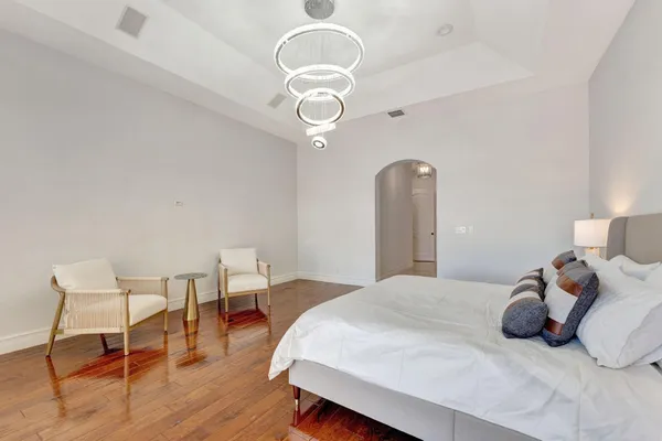 a spacious bedroom with a bed and a chandelier