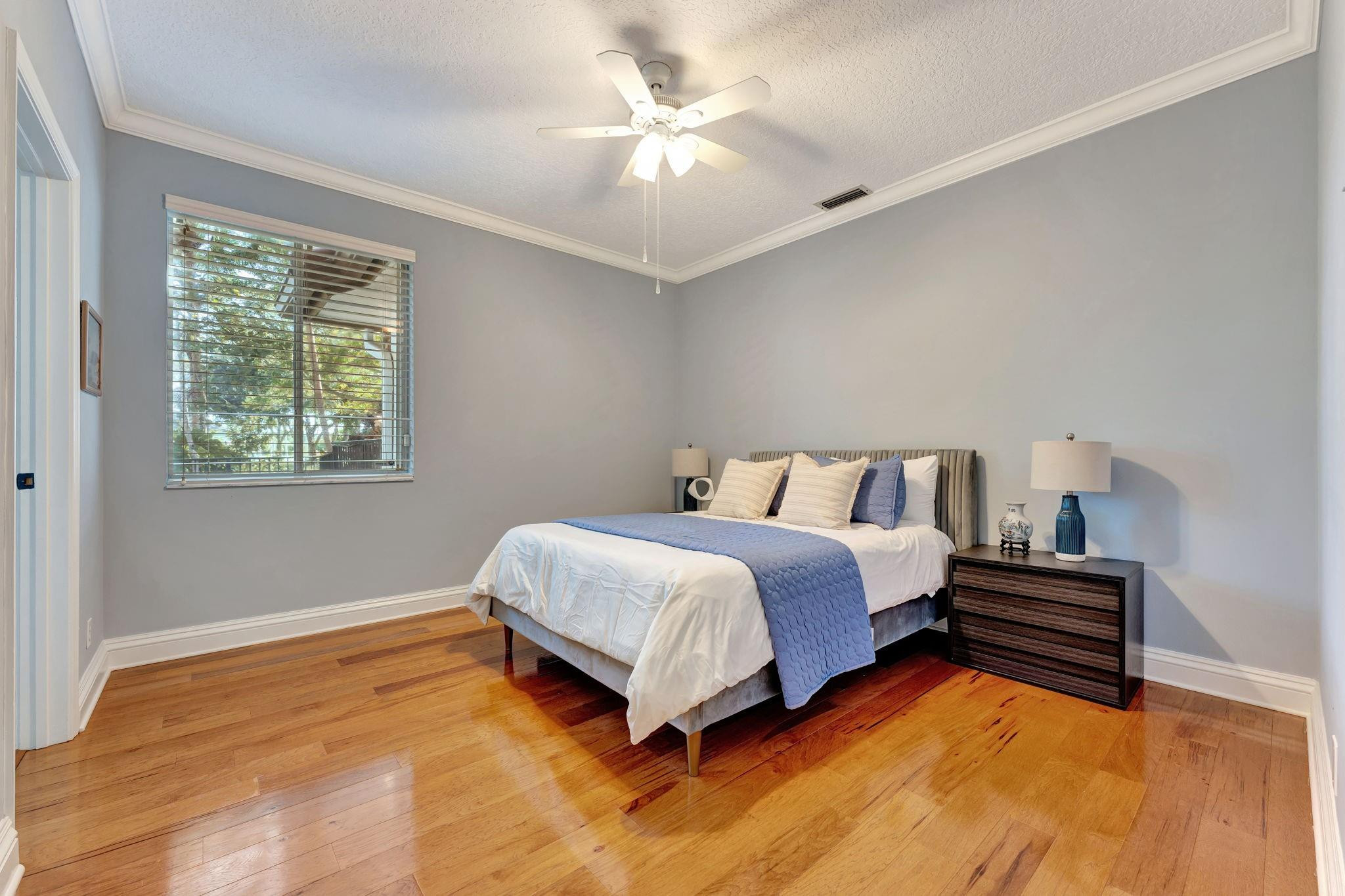 3460 Windmill Ranch Road Weston, FL 33331 - Photo 48 of 75 a spacious bedroom with a bed and a chandelier