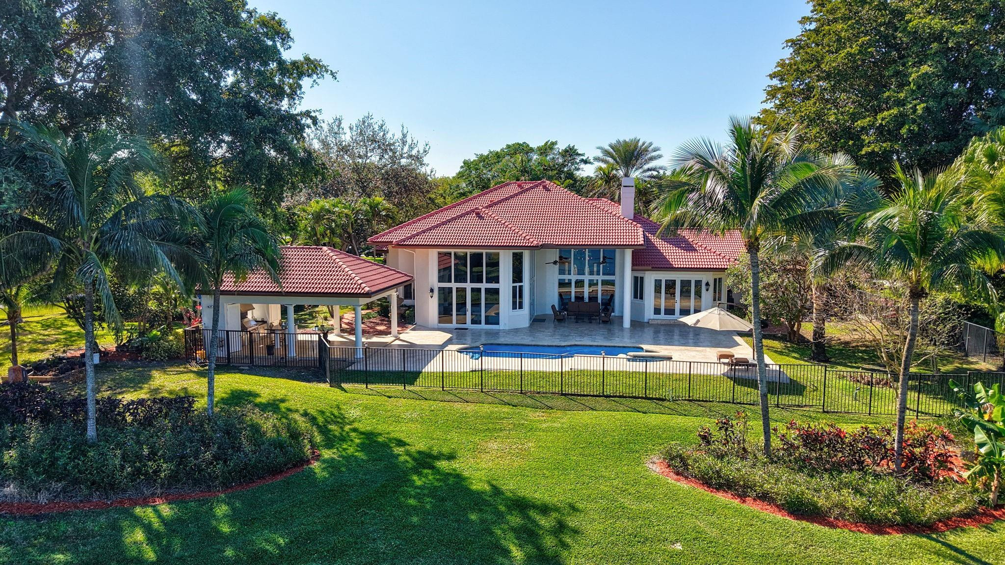 3460 Windmill Ranch Road Weston, FL 33331 - Photo 70 of 75 a view of a house with swimming pool and a yard