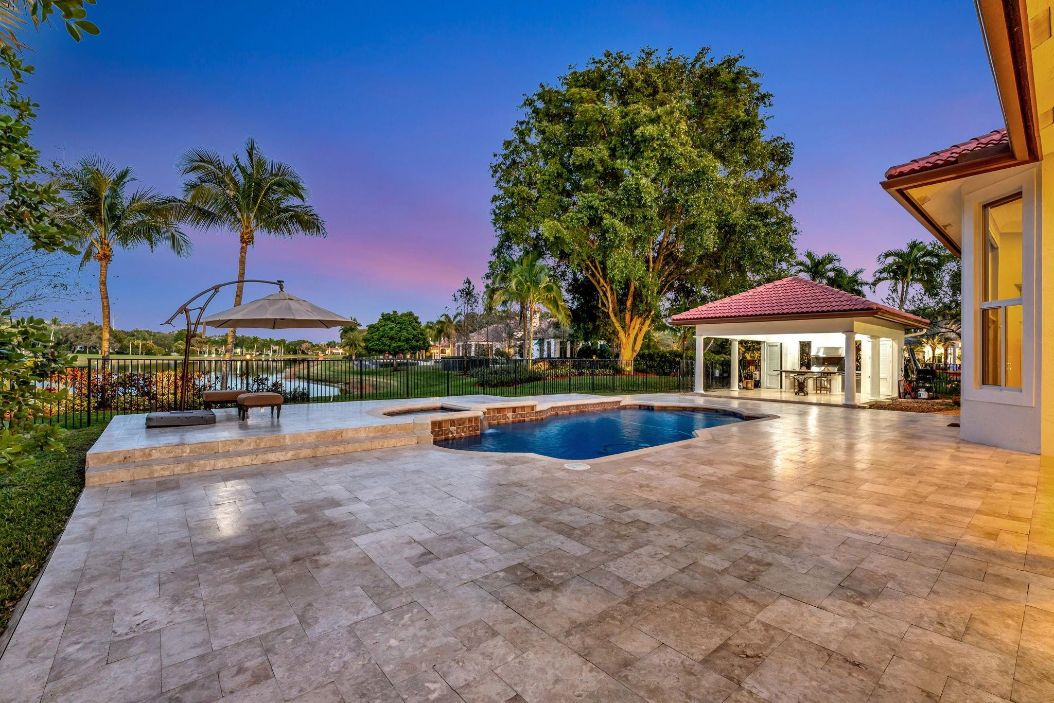 3460 Windmill Ranch Road Weston, FL 33331 - Photo 72 of 75 a view of a swimming pool with lawn chairs under an umbrella