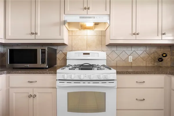 a stove top oven sitting inside of a kitchen