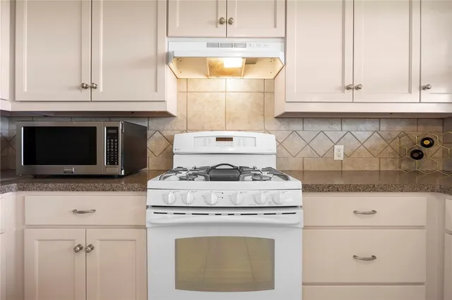 a stove top oven sitting inside of a kitchen