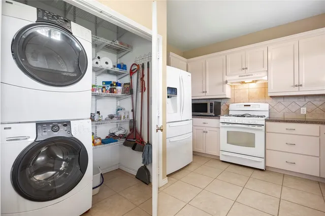 a kitchen with a stove top oven and a washer dryer
