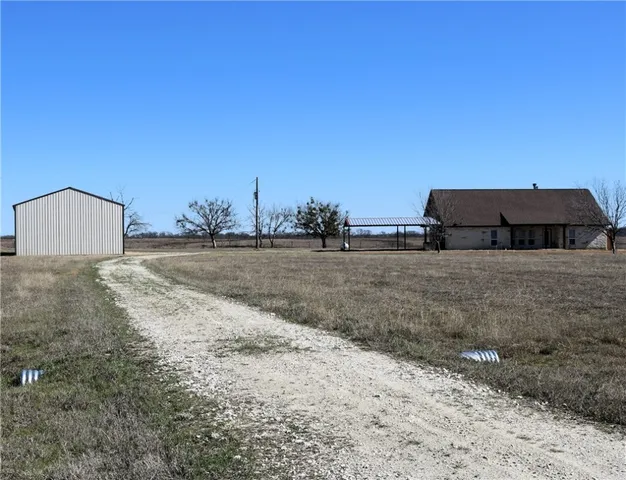 a front view of a house with a yard and fountain