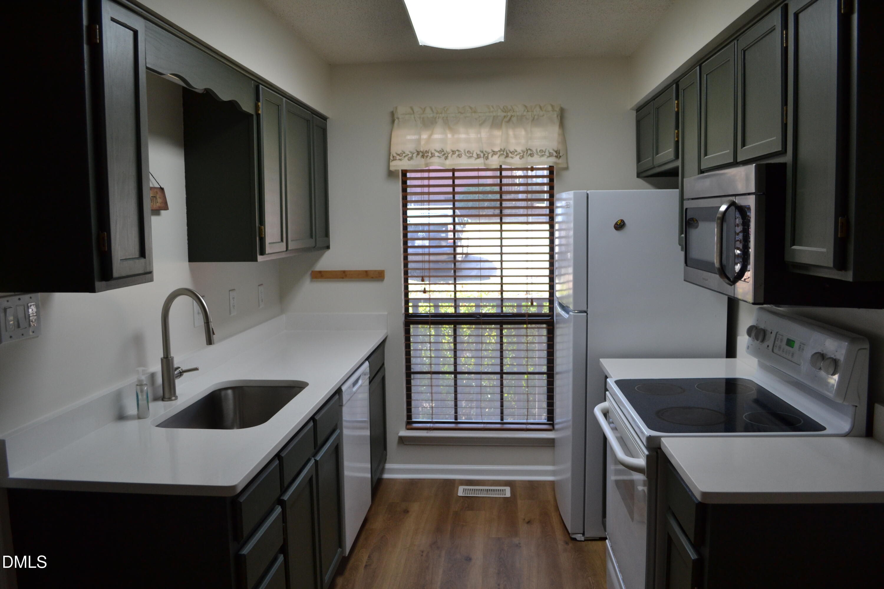 4018 The Oaks Drive Raleigh, NC 27606 - Photo 1 of 49 a kitchen that has a sink and a stove