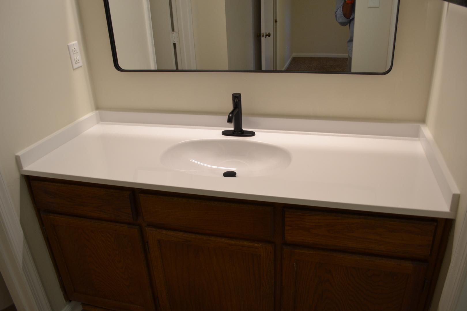 4018 The Oaks Drive Raleigh, NC 27606 - Photo 17 of 49 a bathroom with a sink and a mirror