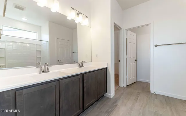 a bathroom with a double vanity sink and mirror with shower