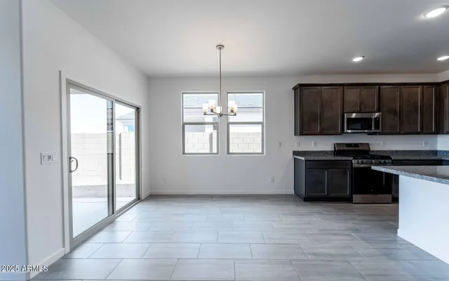 a kitchen with kitchen island granite countertop a sink cabinets and stainless steel appliances