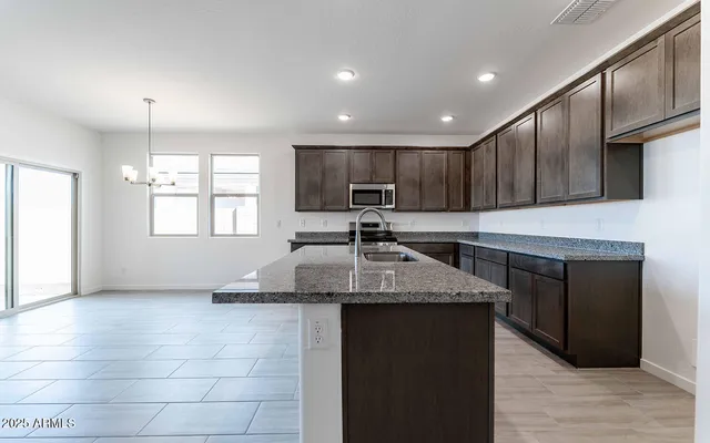 a kitchen with stainless steel appliances granite countertop a stove a sink and a refrigerator