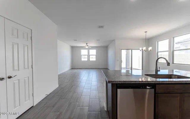 a kitchen with kitchen island granite countertop a sink window and cabinets