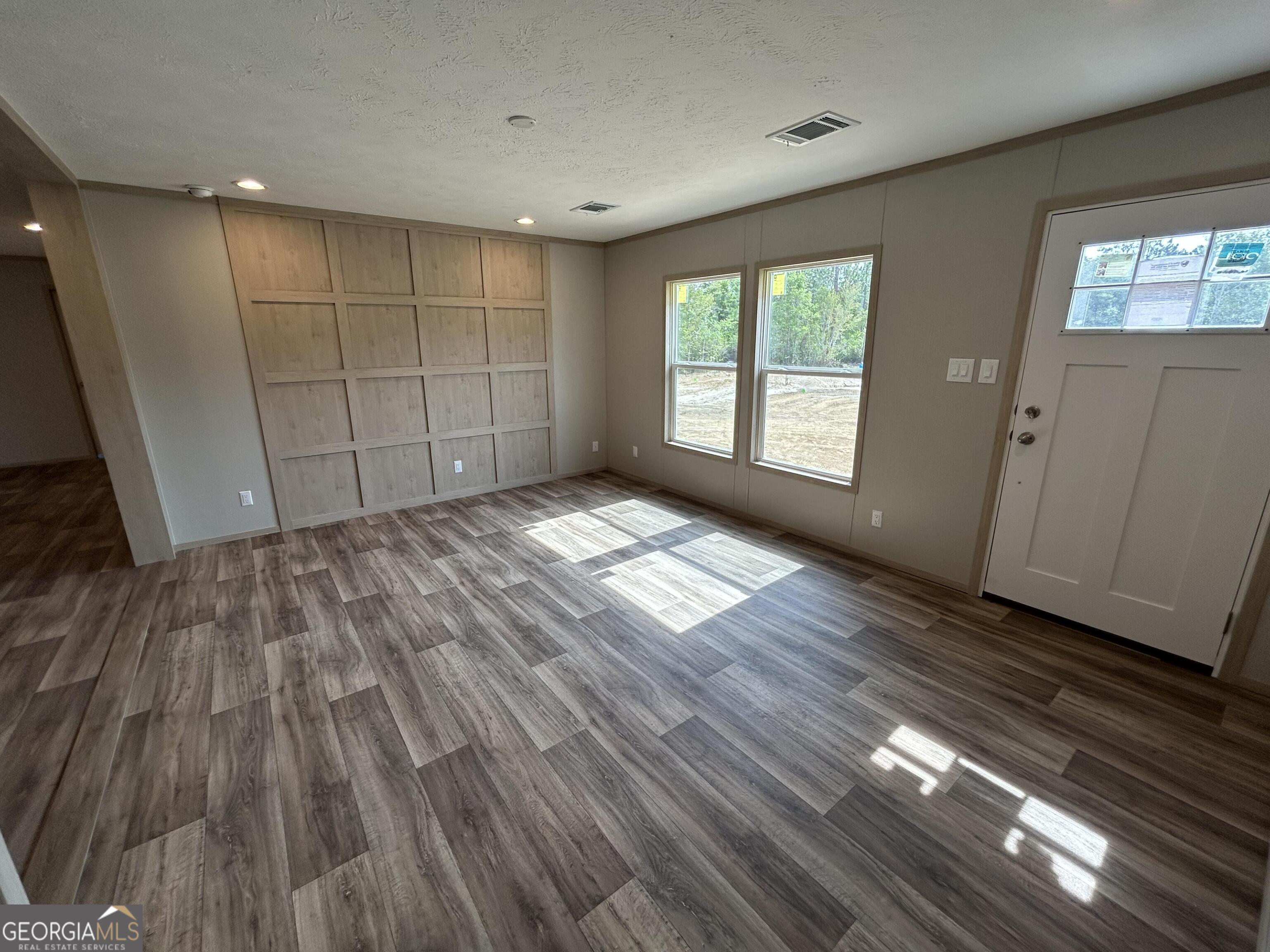 640 Elmer Thrift Road Waycross, GA 31503 - Photo 13 of 23 a view of empty room with wooden floor and fan