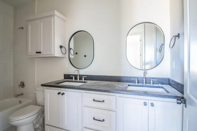 a bathroom with a granite countertop bathtub and a sink