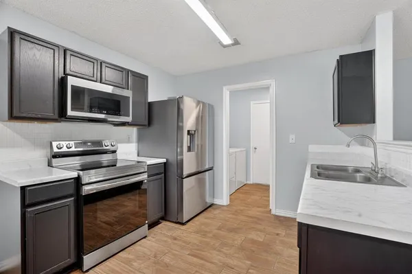 a kitchen with a refrigerator microwave and sink
