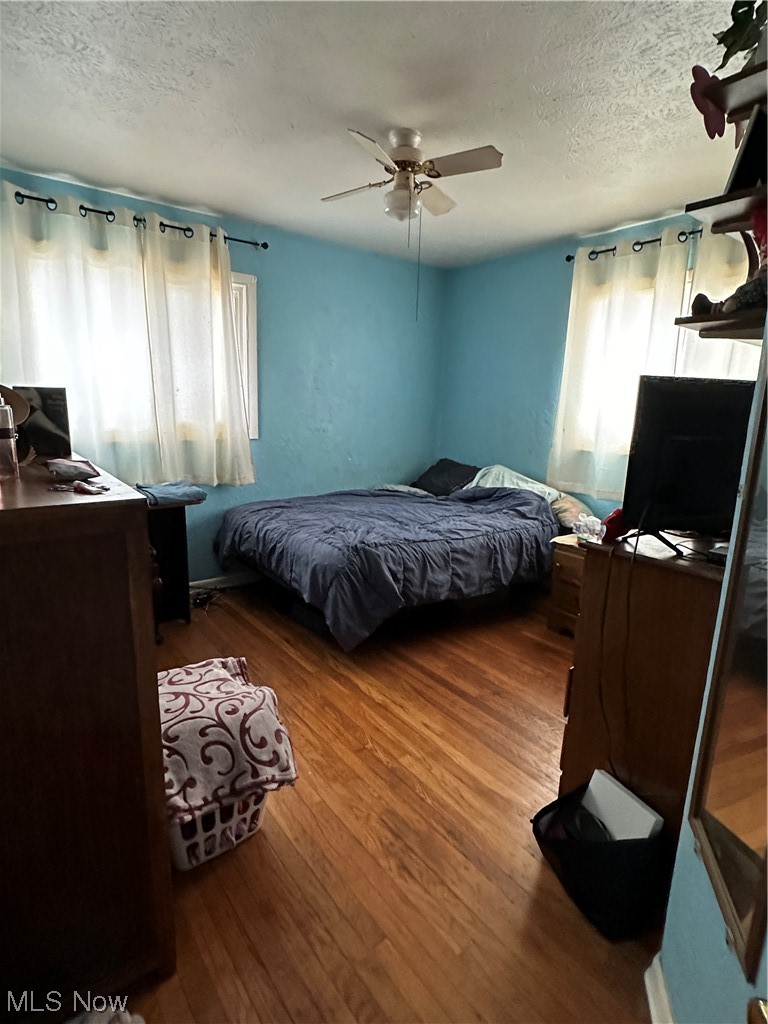 49890 Middle Ridge Road Amherst, OH 44001 - Photo 16 of 26 Bedroom with dark hardwood / wood-style floors, ceiling fan, and a textured ceiling