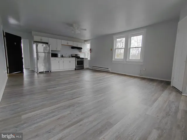 a view of a kitchen with wooden floor and electronic appliances