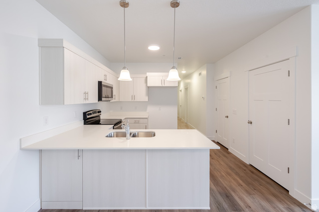 675 West 4500th South, Unit P302 Mapleton, UT 84664 - Photo 15 of 16 Modern kitchen featuring white cabinetry, light-toned countertops, and stainless steel appliances