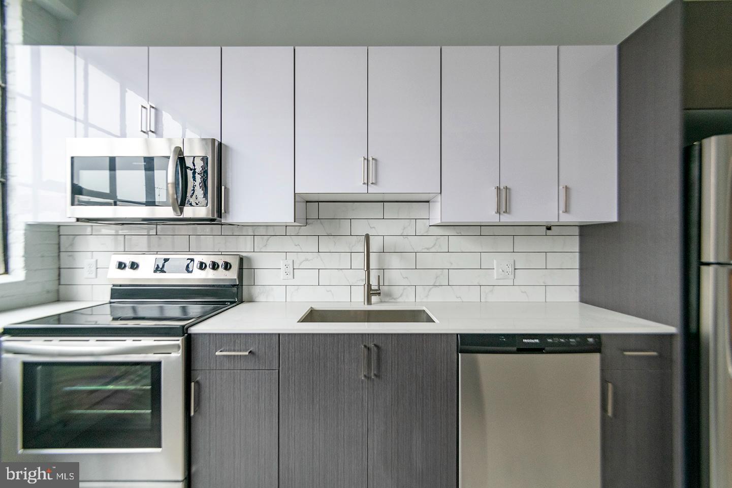 412 South 13th Street, Unit 307 Philadelphia, PA 19147 - Photo 4 of 16 a kitchen with stainless steel appliances granite countertop a sink stove and cabinets