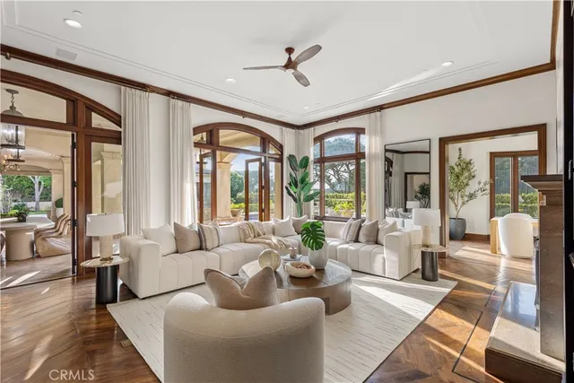 a living room with furniture ceiling fan and a large window