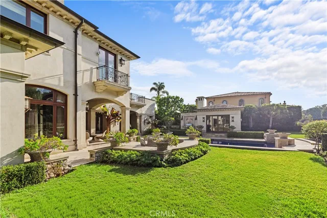 a view of a house with a big yard potted plants and large tree