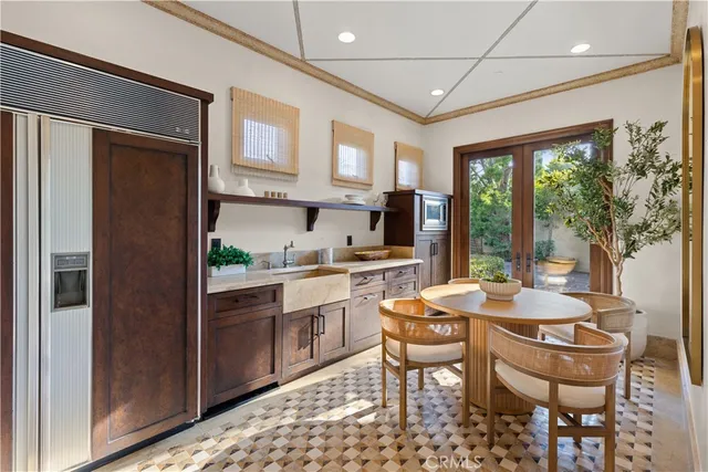 a dining room with stainless steel appliances granite countertop a table and chairs
