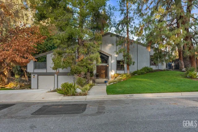 front view of a house with a yard and an trees