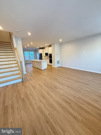 a view of a kitchen with wooden floor and a window