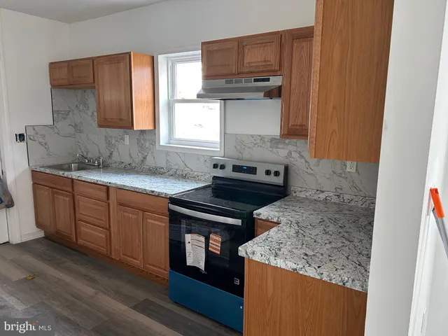 a kitchen with stainless steel appliances granite countertop a sink stove and cabinets