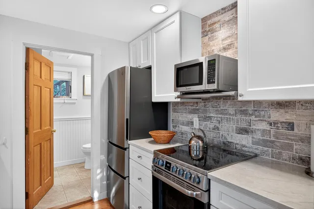 a kitchen with stainless steel appliances a refrigerator a stove a microwave cabinets and a sink