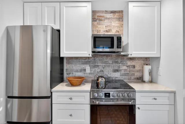 a kitchen with stainless steel appliances white cabinets and a sink