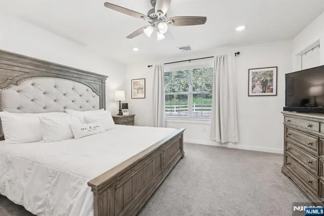 a spacious bedroom with a bed and a flat screen tv