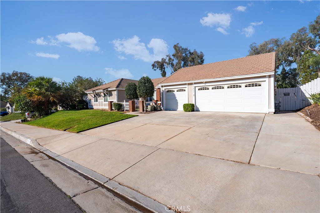 10451 Morning Ridge Drive Moreno Valley, CA 92557 - Photo 11 of 56 a view of a white house with a yard and potted plants
