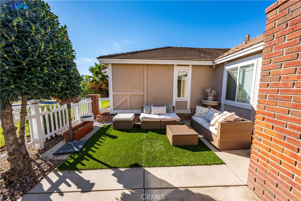 10451 Morning Ridge Drive Moreno Valley, CA 92557 - Photo 13 of 56 a view of a patio with couches chairs potted plants and a palm tree