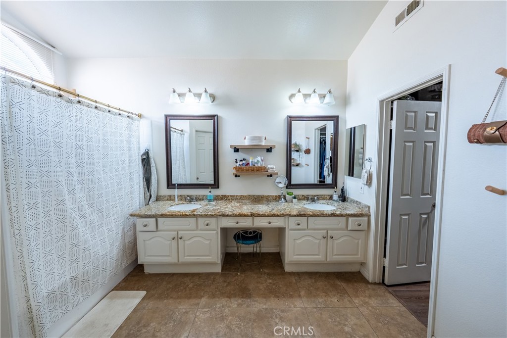 10451 Morning Ridge Drive Moreno Valley, CA 92557 - Photo 29 of 56 a spacious bathroom with a granite countertop sink a mirror and a bathtub