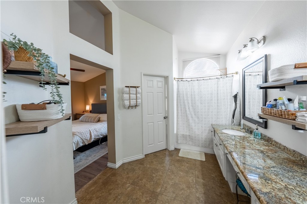 10451 Morning Ridge Drive Moreno Valley, CA 92557 - Photo 31 of 56 a bedroom with furniture and a chandelier