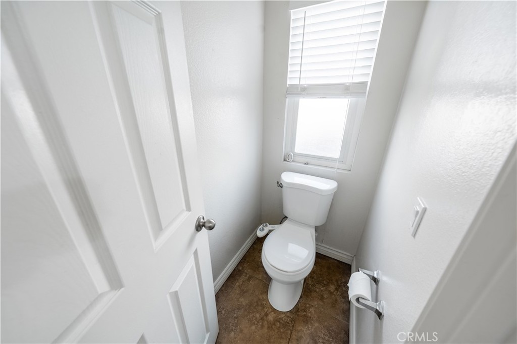 10451 Morning Ridge Drive Moreno Valley, CA 92557 - Photo 32 of 56 a white toilet sitting next to a window