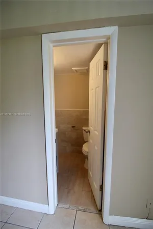 a kitchen with a refrigerator and white cabinets