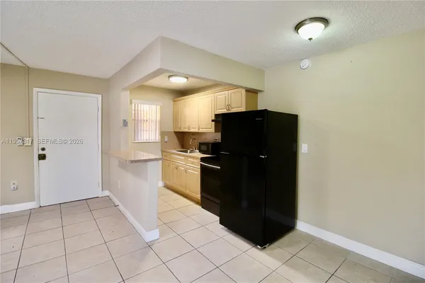 a kitchen with a refrigerator and cabinets