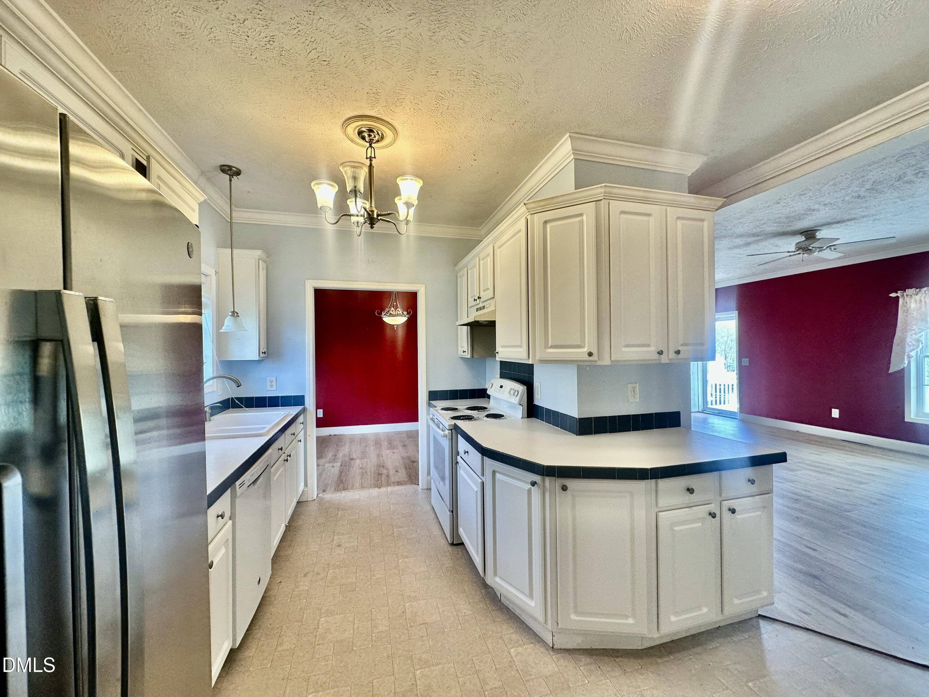 155 Collin Drive Roxboro, NC 27574 - Photo 6 of 20 a kitchen with stainless steel appliances granite countertop a sink a refrigerator and a stove