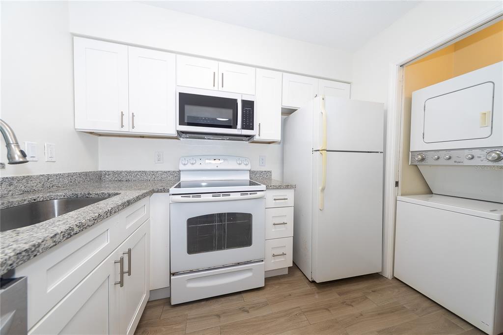8557 Pilgrim Court New Port Richey, FL 34653 - Photo 11 of 29 a kitchen with white cabinets and white appliances
