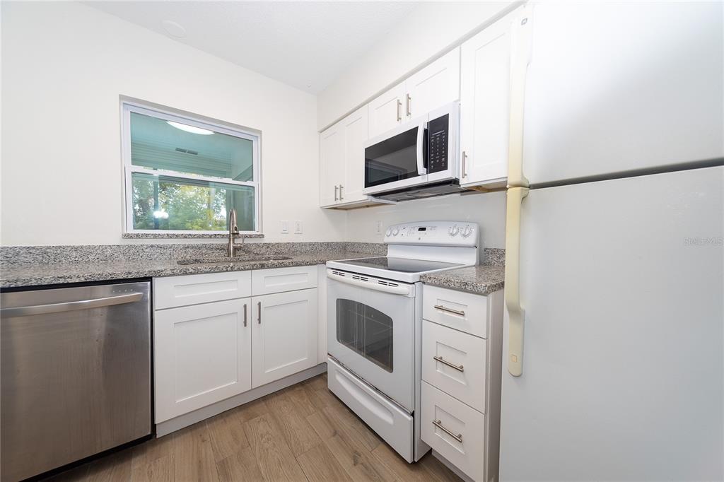 8557 Pilgrim Court New Port Richey, FL 34653 - Photo 12 of 29 a kitchen with white cabinets stainless steel appliances and sink