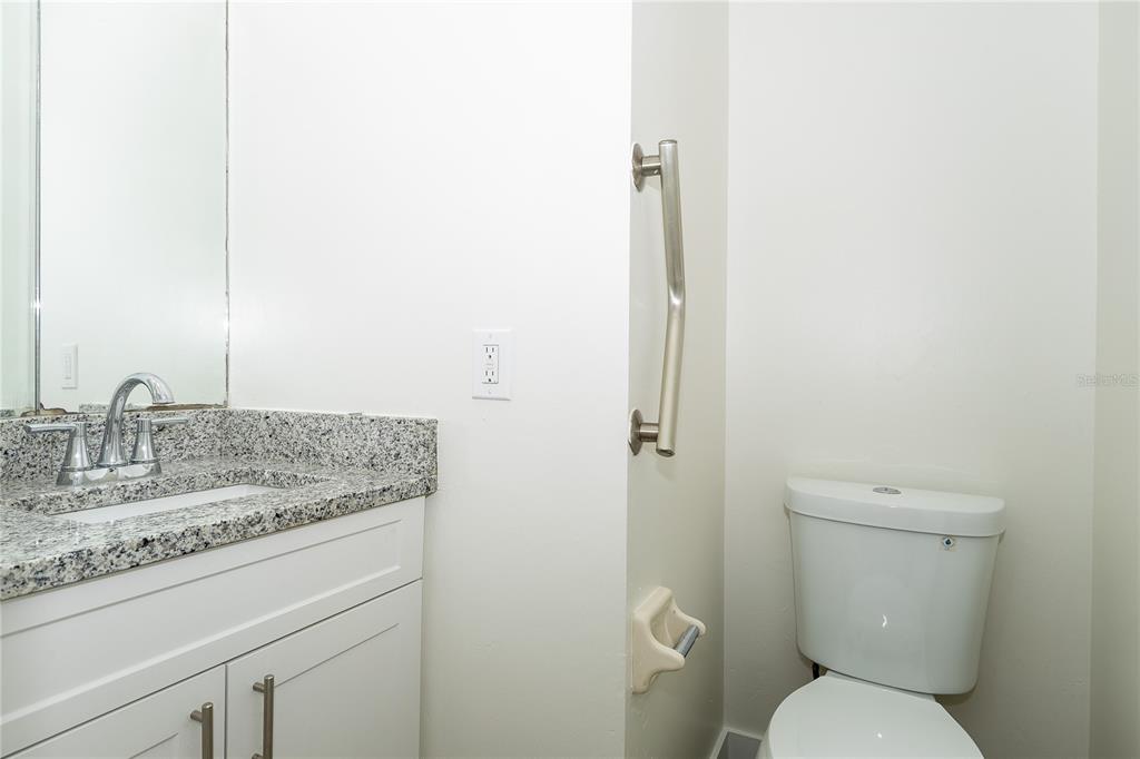 8557 Pilgrim Court New Port Richey, FL 34653 - Photo 6 of 29 a bathroom with a granite countertop toilet and a sink