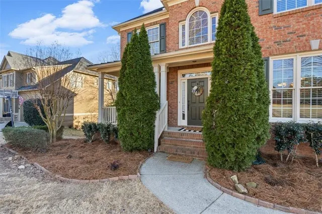 a view of a brick house with many windows next to a yard