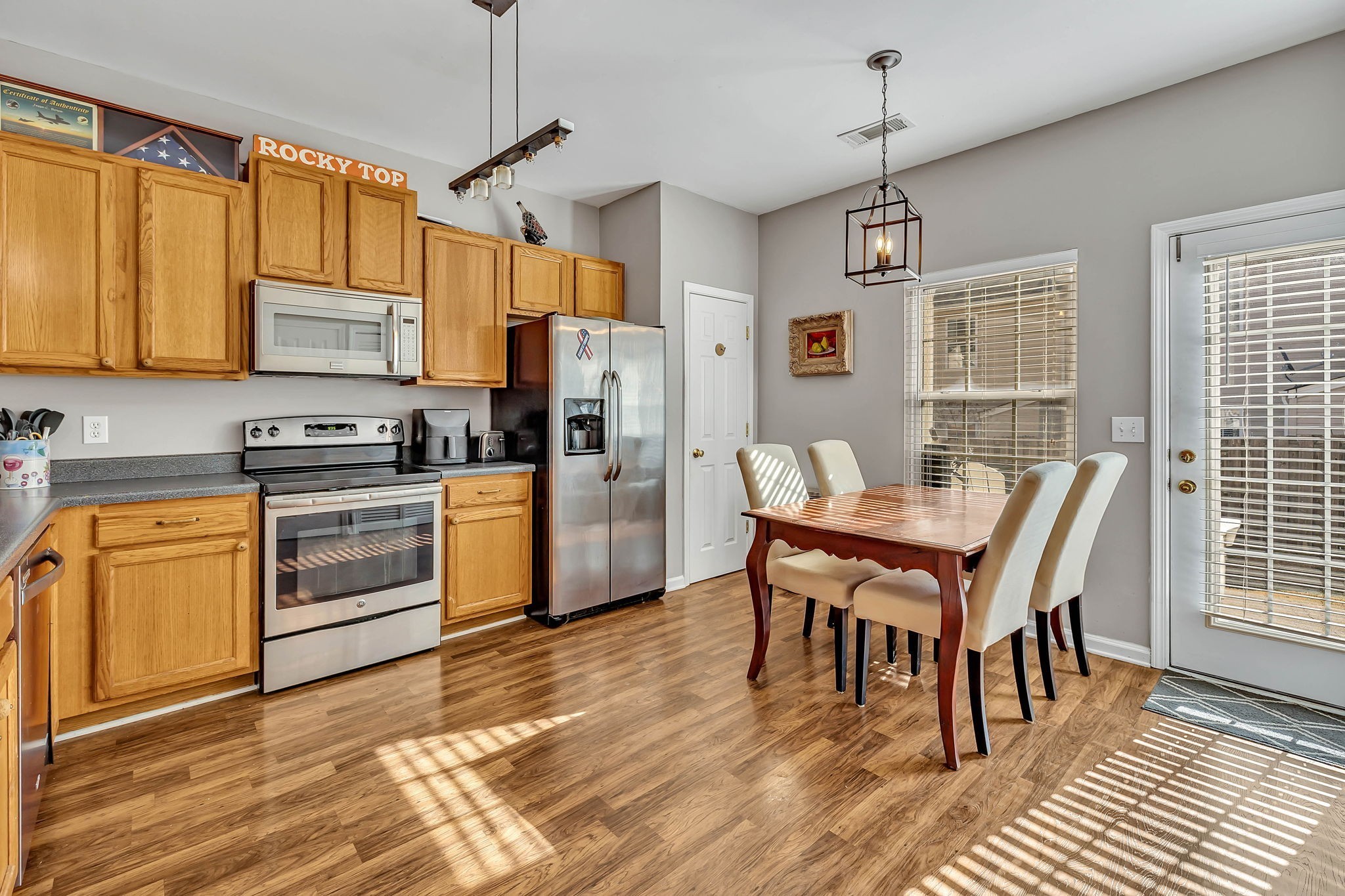 1101 Downs Boulevard, Unit I104 Franklin, TN 37064 - Photo 6 of 22 a kitchen with stainless steel appliances wooden floor dining table chairs and wooden cabinets