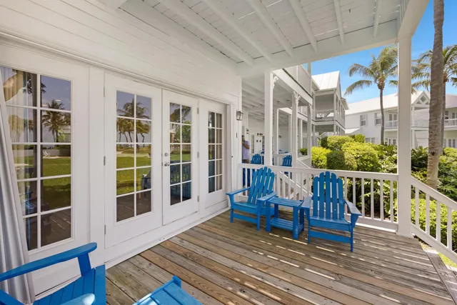 a view of a patio with lawn chairs floor to ceiling window and wooden floor