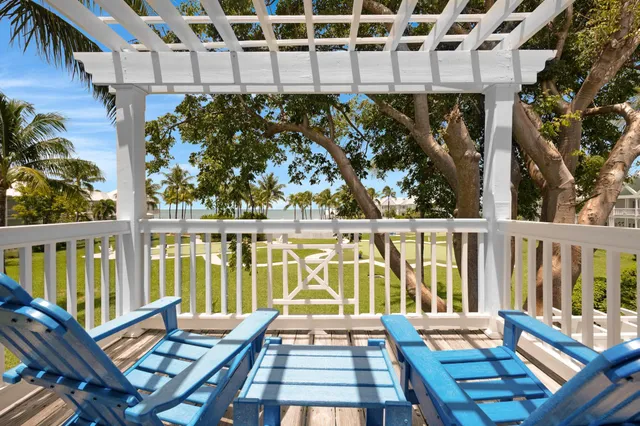 a view of a balcony with wooden chairs