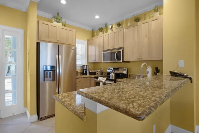a kitchen with kitchen island granite countertop a refrigerator a stove and a sink