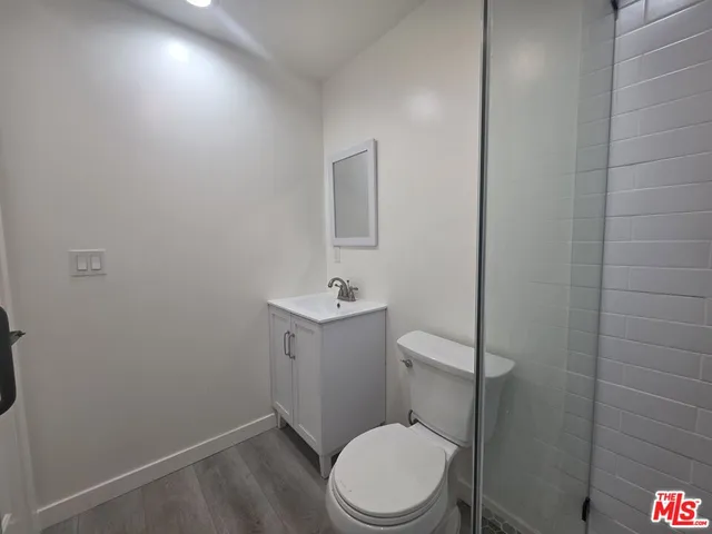 a bathroom with a toilet sink vanity and mirror