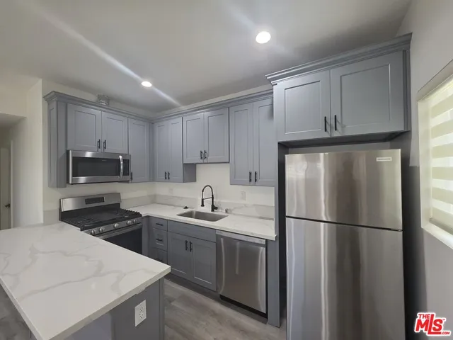 a kitchen with a refrigerator a sink and cabinets