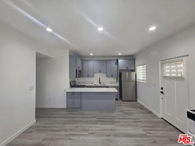 a view of kitchen with wooden floor and electronic appliances